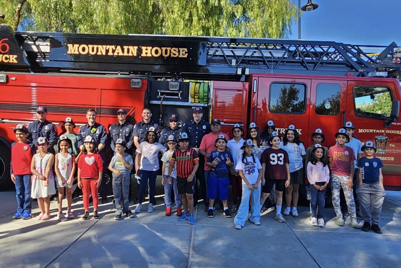 Coach Gaurav Negi with Mountain House firefighters in front of a fire truck