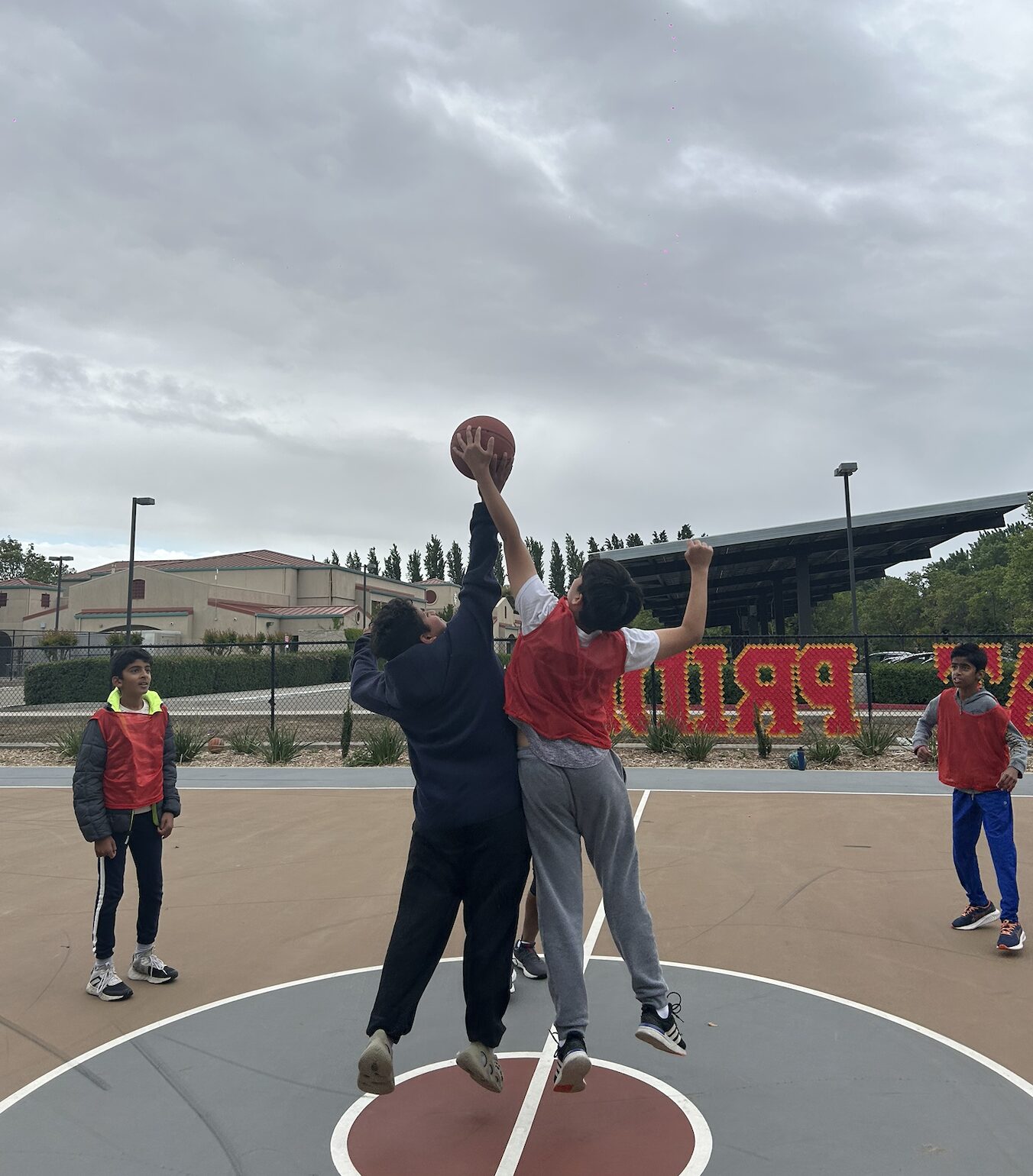 Group of players watching a shot arc toward the hoop